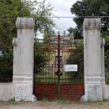 Praticamente di fronte sorge un�altra villa disabitata. L'inferriata d'ingresso, contraddistinta da un cartello di messa in affitto, ha un insolito motivo centrale che ricorda la forma di un calice ed � fiancheggiata da colonne con volute squamate